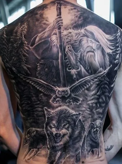 Татуировка на всю спину: волхв с посохом, сова и стая волков на фоне леса, символизирующие мудрость, силу и связь с природой.