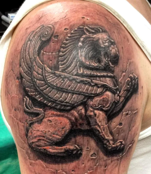 Тату крылатый лев Скифов в камне на плече