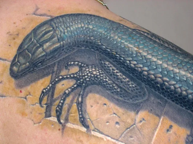 Тату ящер на каменном плече и шее