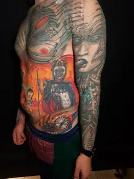 Мужская рукавная татуировка в стиле киберпанк с изображением военного в доспехах и технологичными элементами, включающая яркие красные и оранжевые акценты на груди и руках.