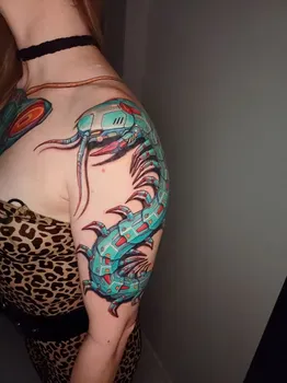 Киберпанковская татуировка с изображением механической сколопендры, выполненная в ярких бирюзовых и красных оттенках, символизирующая сочетание природы и технологий.