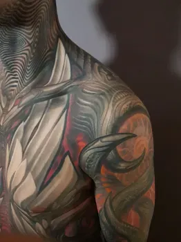 Татуировка на плече в стиле абстракционизма с элементами киберпанка, включающая сложные геометрические формы, красные акценты и динамичные линии, создающие эффект движения.
