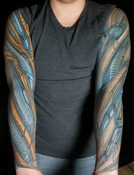 Киберпанковские татуировки на обеих руках с изображением технологичных элементов и механических конструкций, выполненные в золотистых и синих тонах, создающие эффект высокотехнологичной брони