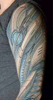 Татуировка в стиле биомеханики на плече с изображением киберпанковских элементов, создающих эффект сложной роботизированной структуры с яркими синими и желтыми акцентами.