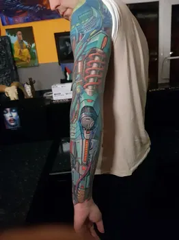 Яркая киберпанковская татуировка на руке с изображением технологичных элементов, включая сложные механизмы и трубки, выполненная в синих и красных тонах.