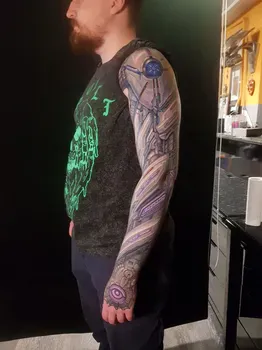 Татуировка на руке в стиле киберпанк с изображением роботизированных элементов, с яркими фиолетовыми и синими акцентами, создающая футуристичный и технологичный вид.